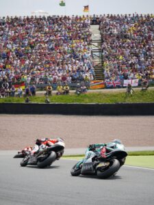 MotoGP riders racing in front of a packed crowd